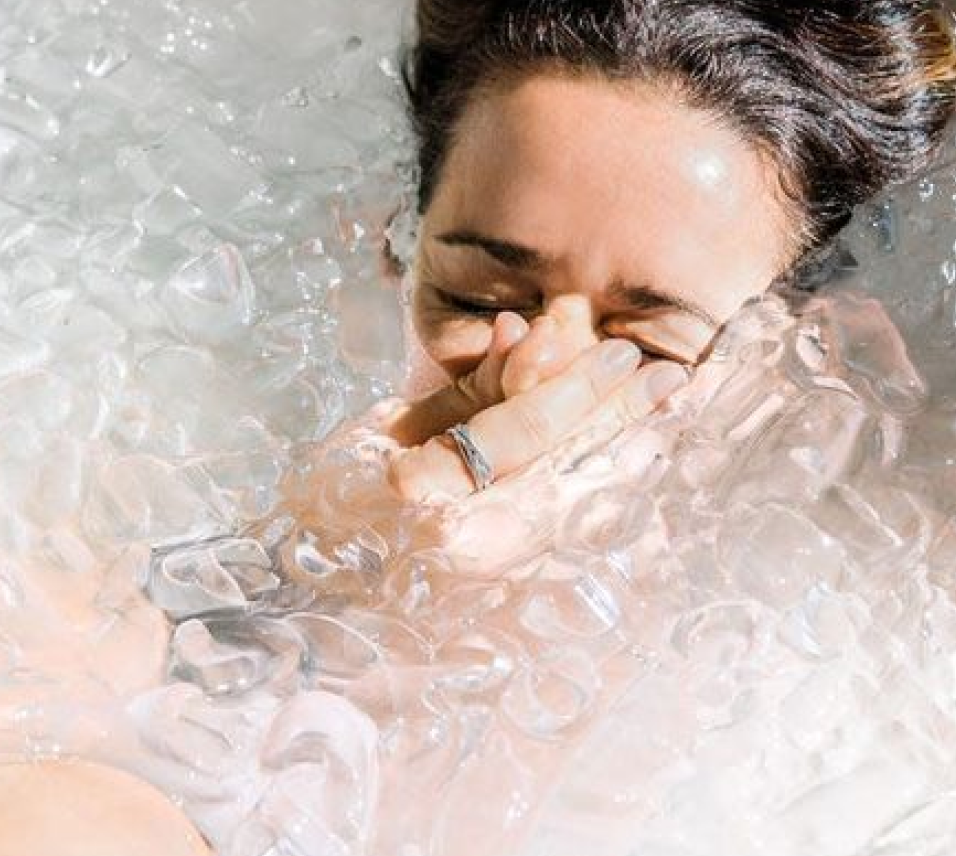 Person stepping into a cold plunge outdoors